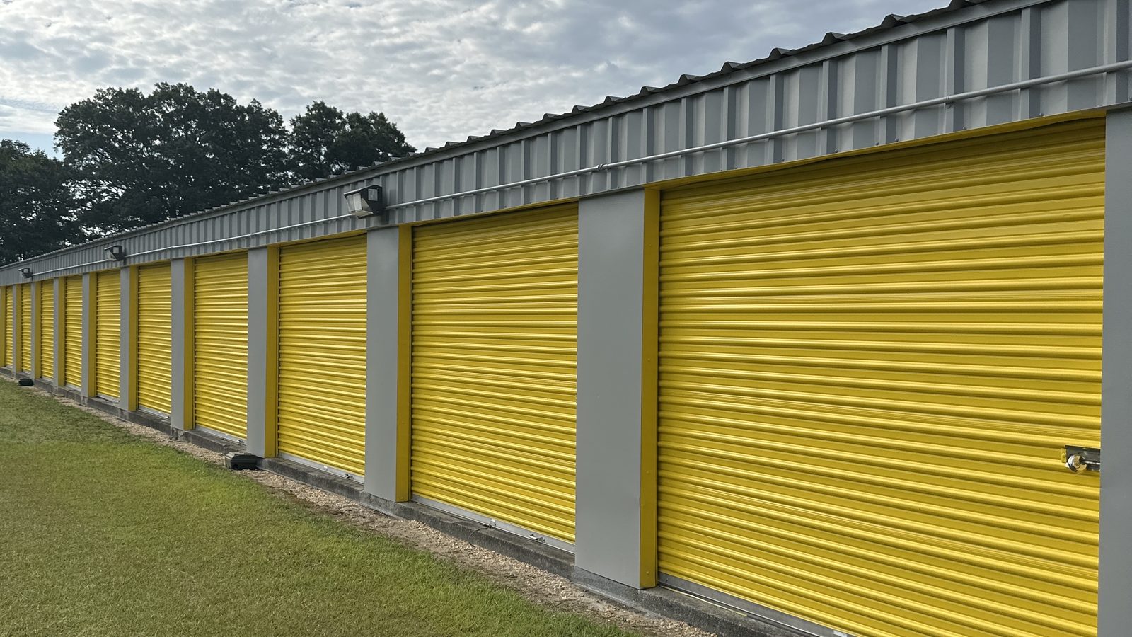 Row of yellow roll-up doors on ground-floor drive-up units at Self Storage Goldsboro